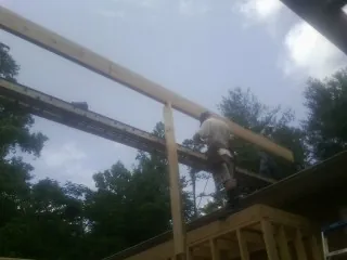 Carpenter setting a ridge beam over a new addition frame — Ice Dam Removal by Roofing Brothers in Arcanum