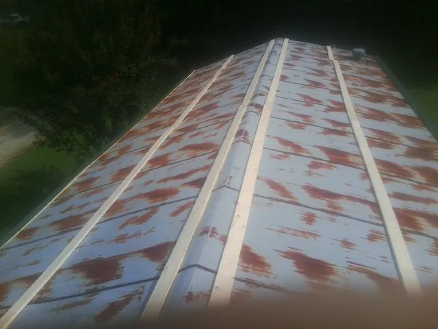 Rusted metal roof panels with new wood purlins before replacement — Storm Damage Roof Repair in Arcanum by Roofing Brothers
