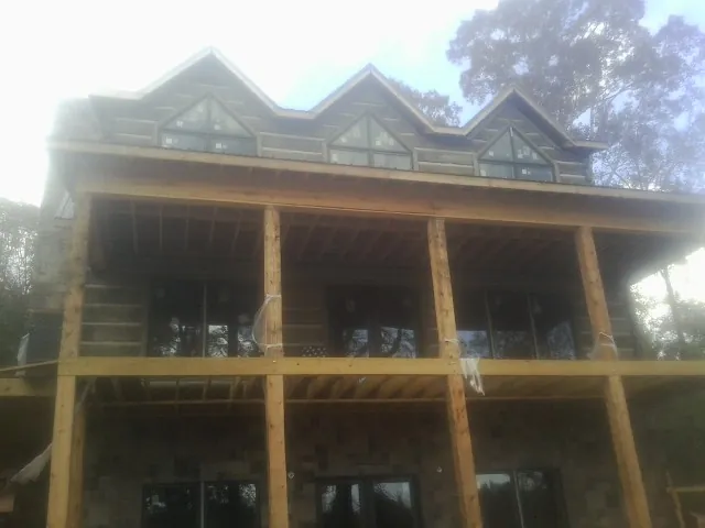 Dormers and porch framing on a large log home under construction — Roof Coating work by our crew in Arcanum