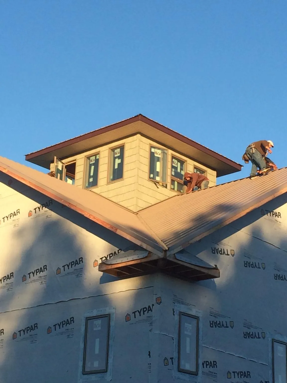 Roofers working around a rooftop cupola on a new metal roof at sunset — Roof Waterproofing in Arcanum by Roofing Brothers